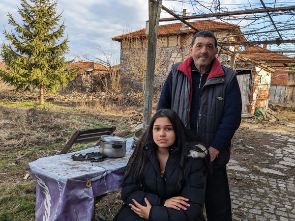 Tsvetomila and her father outside their modest home in Bulgaria